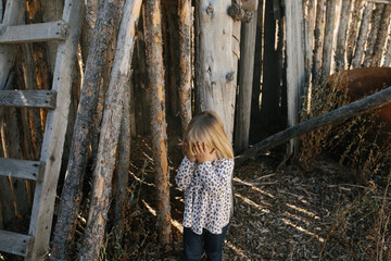 little girl covering her eyes playing hide and seek