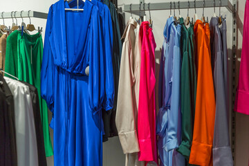 Bright elegant women's dresses on hangers in the store. Fashion & Style.