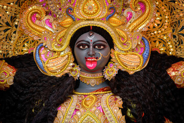 Idol of Goddess Maa Kali at a decorated puja pandal in Kolkata, West Bengal, India. Kali puja also known as Shyama Puja is a famous religious festival of Hinduism. - obrazy, fototapety, plakaty