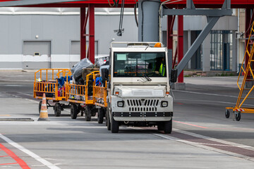 Tow tractor pulling luggage carts at airport apron