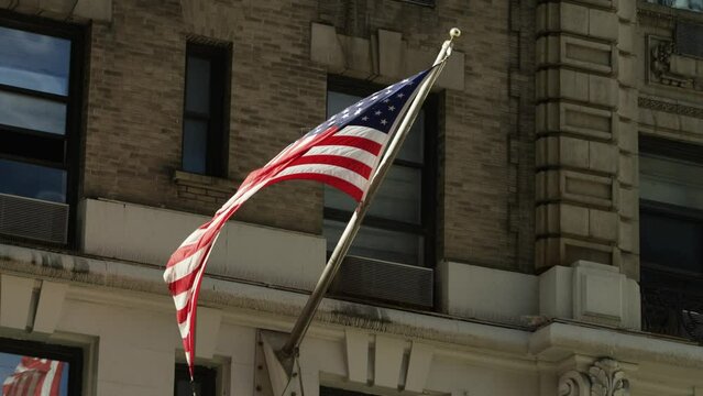 USA flag blowing outside of old New York City building close up RED 5K slowmotion 96 FPS