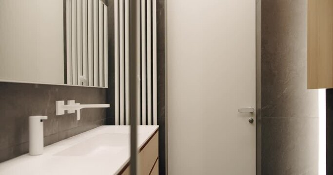 Mirror and shower head, bathtub modern design. Luxury cozy white Apartment. Modern bathroom with simplicity design. Bathroom Interior, Minimalist interior in brown colors with bathroom accessories.