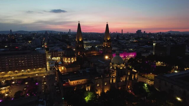 Aerial view over the illuminated Guadalajara Cathedral, dusk in Mexico - rising, drone shot