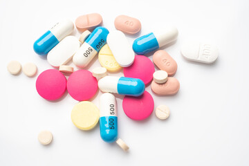 different color tablets and Pill capsule on white background, flat lay