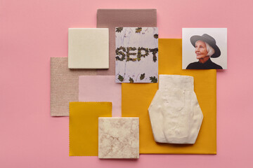 Horizontal directly from above flat lay shot of senior womans photo, pieces of fabrics, ceramic tiles and gypsum figure in shape of vase on pink surface