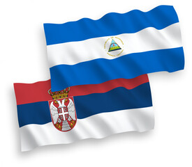 National vector fabric wave flags of Nicaragua and Serbia isolated on white background. 1 to 2 proportion.