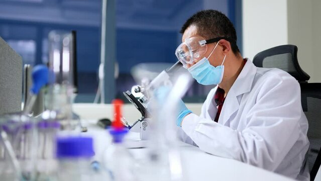 chinese man doctoro doing chemical experiment in library