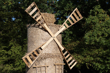 Stary słomiany i drewniany wiatrak na wsi. - obrazy, fototapety, plakaty