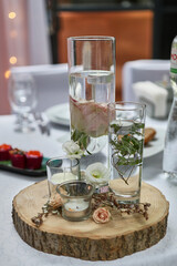 Stand in the form of a cut of a tree with vases and candles.