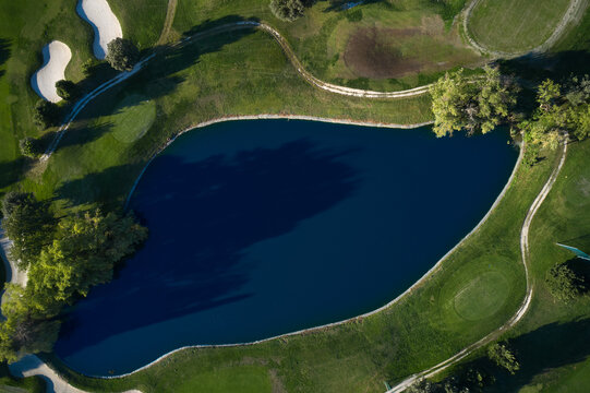 Small lake on golf course aerial view. Golf field top view.