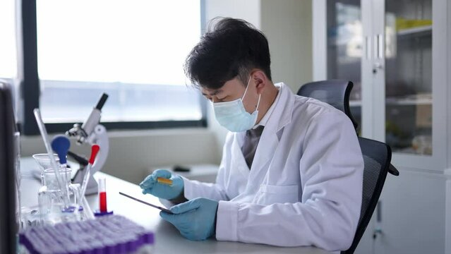 young chinese doctor doing  chemical experiment in library