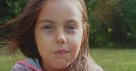 Portrait of little girl in nature. little girl eats sweet chocolate food. healthy food child having breakfast concept of childhood dream. daughter girl looks at the camera and chews candy and smiles. 