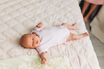 Little baby kid newborn lying indoors at home in the bed