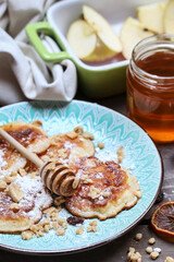 Apple fritters with powdered sugar, honey and muesli.