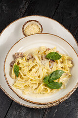 delicious pasta with cheese, greens, sauce in a restaurant
