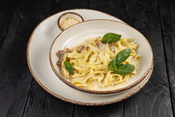 delicious pasta with cheese, greens, sauce in a restaurant
