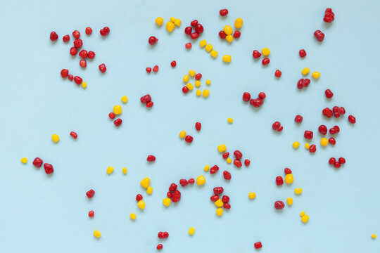 Red and yellow colored candy nerds sprinkled on a blue background.