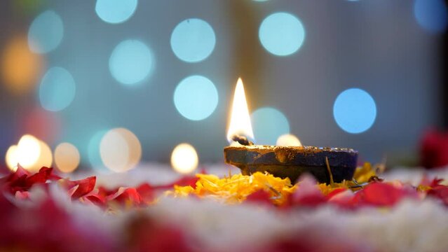 Closeup shot of a Diwali Diya - Diwali lamp kept on the floor with flower rangoli  Diwali festival  Diwali decoration . A brightly burning colorful Diya kept on a floral platform on the occasion of...