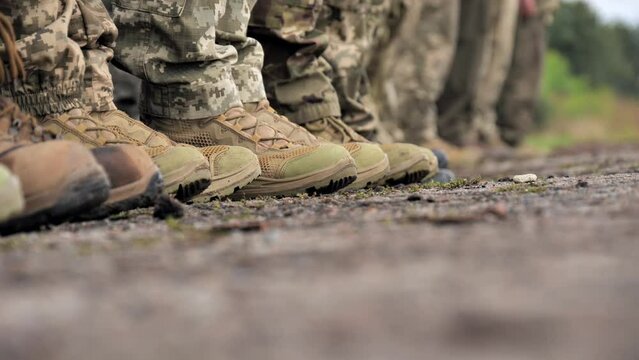 Close-up of legs of army soldiers in camouflage uniforms and boots standing in formation
a column of soldiers lined up in formation