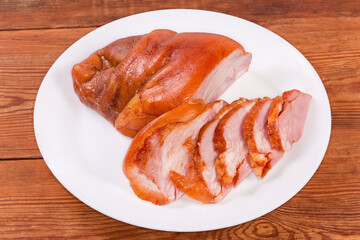 Boiled-smoked pork knuckle on the dish on rustic table