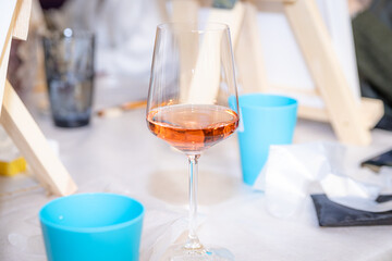 Glass with wine on the table among drawing accessories 