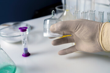 Close up of the hand of a scientist working with laboratory samples of nutritional supplements additive.