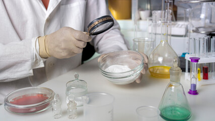 The hands of a scientist working with laboratory samples of nutritional supplements additive.