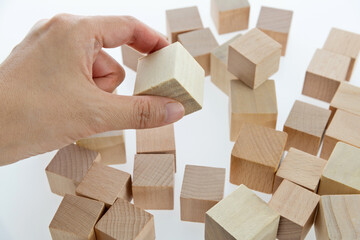 Human hand picking up a wooden block