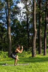 young man, doing yoga or reiki, in the forest very green vegetation, in mexico, guadalajara, bosque colomos, hispanic,