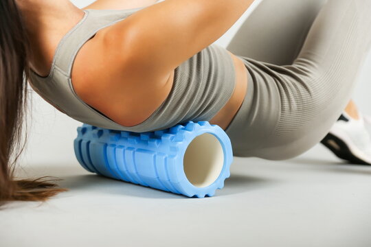 woman doing exercises with yoga foam grid roller