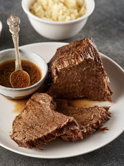 Roast beef, beef stew, sliced fried piece of beef with sauce on a plate.