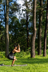 young man, doing yoga or reiki, in the forest very green vegetation, in mexico, guadalajara, bosque colomos, hispanic,