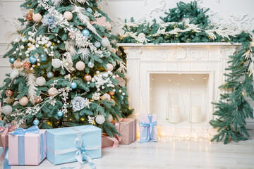 A beautifully decorated bright room for the New Year. Christmas tree, gifts under the tree. the fireplace is decorated with garlands