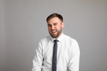 Portrait of happy businessman on light grey background. Personality concept
