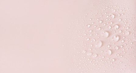 water drops of transparent gel serum on a pastel beige background	
