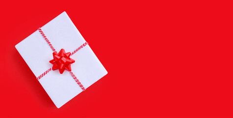 white color gift box christmas present on red background with place for text	
