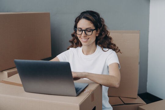 Girl works at laptop preparing parcels of online store for sending. Delivery service, ecommerce