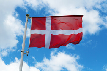The flag of Denmark against the blue sky.