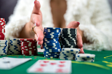 woman in a casino with many chips that she wraps after a big poker win.