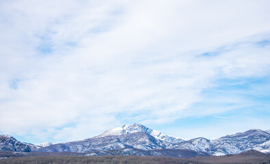 snow capped mountains with blue sky and clouds