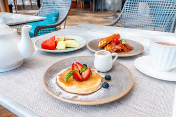 Breakfast in hotel with pancake and belgian waffles in outdoors cafe