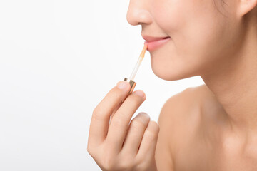 Portrait young asian woman looking mirror applying makeup lipstick at room