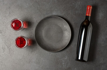 Red wine in a bottle. Black concrete background. Flat lay. Copy space.