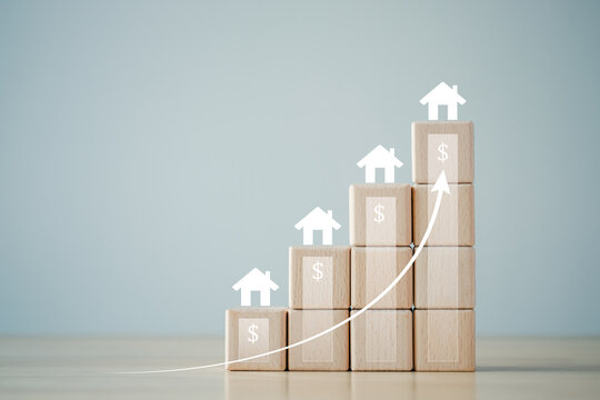 Real estate concept. Property investment, refinance, loan, tax, mortgage, increase of home price or interest rate. House with dollar icon and rise of arrow on wooden block. planning to saving money.