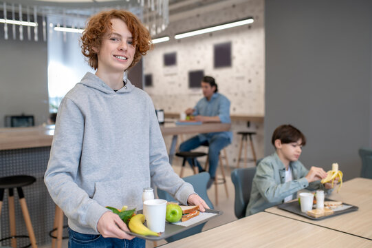 Cheerful pupil posing for the camera in the school canteen
