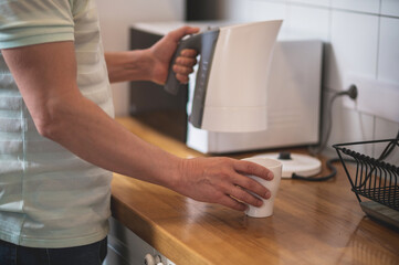 Close up picture of a man holding a kettle