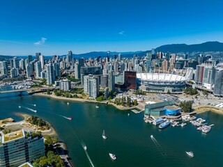 Luftdrohnenansicht der Innenstadt von Vancouver mit modernen Gebäuden und einem Hafen mit festgemachten Booten
