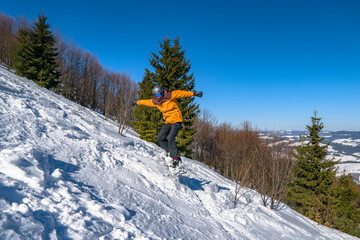 Snowboarder jumps from snow hill. Mountain freeride snowboarding. Winter mountains Carpathians