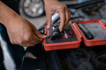 Experienced car service station worker choosing an optical device