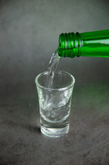 soju is pouring on glass, selective focus in vertical view